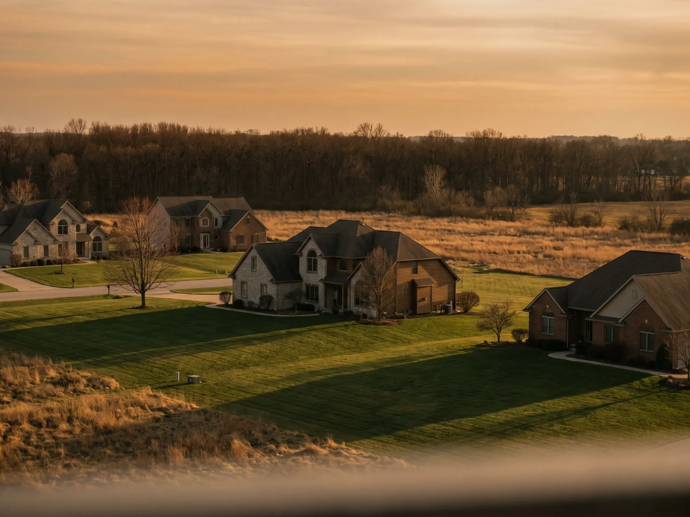 Large lot homes backing onto open land at golden hour. Inspired Law Group serves Homer Glen and the surrounding Will County communities.